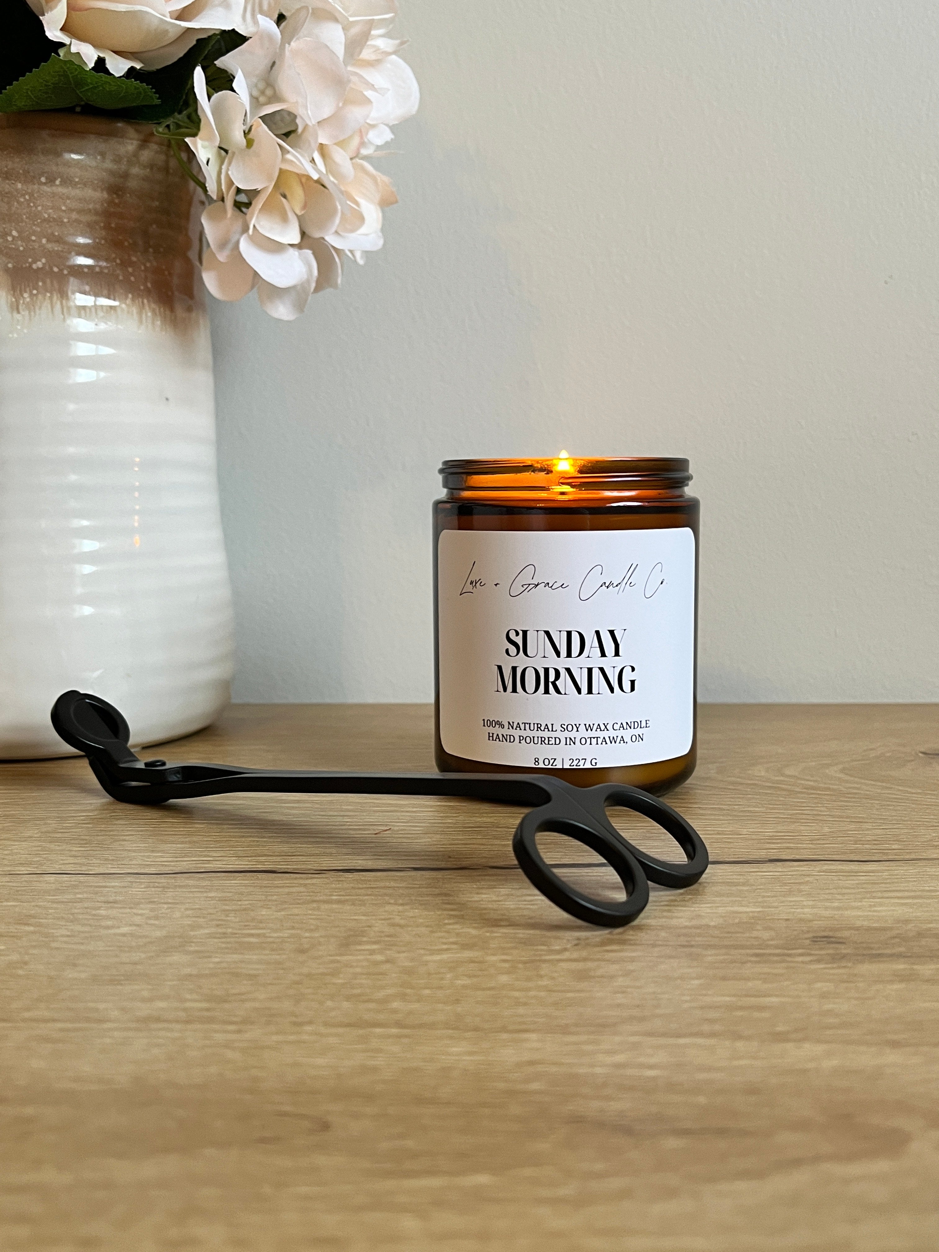 A beautifully lit soy wax candle casting a warm glow in a modern living room, emphasizing ambiance and safety.